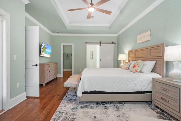 The oversized primary bedroom offers a luxurious king bed, oversized chair with ottoman, desk, easy access to the back deck, Smart HDTV and an en suite bathroom. 
