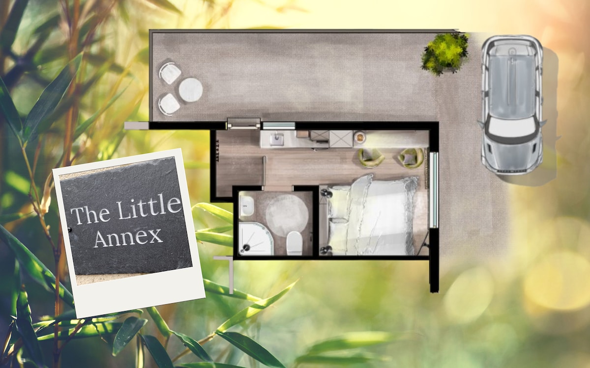 An overhead view of 'The Little Annex' layout is displayed. Key features include a cozy sleeping area, kitchenette, and en-suite shower room. The outside shows designated driveway parking alongside a sign reading 'The Little Annex,' set against a simple, natural background.