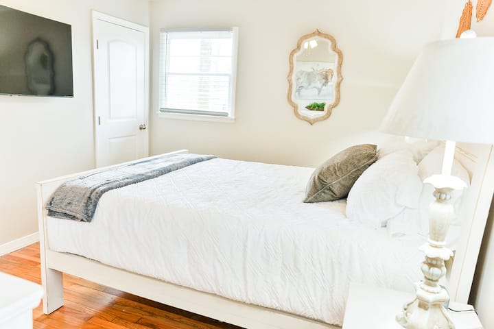 Master bedroom with queen size bed, dresser and two night stands, private bathroom and a 50 inch Smart Tv.