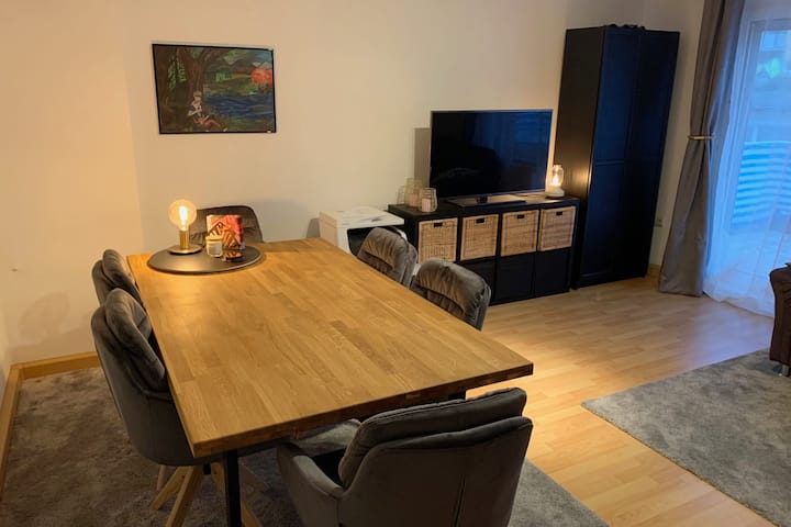 Ძალიან დიდი მისაღები ოთახი სასადილო მაგიდით, 6 ნივთით, ტელევიზორით, აივანზე წვდომით, ასევე, კუთხის ტახტით.