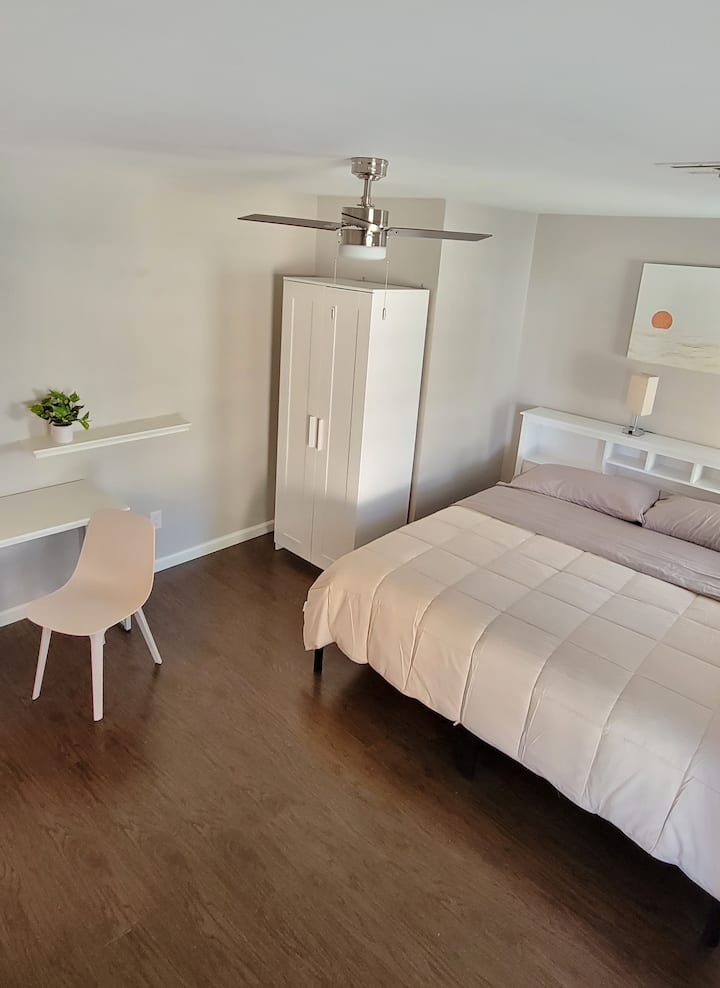 Habitación Coral: cama tamaño king con luz natural y espacio de trabajo dedicado. Incluye baño privado.