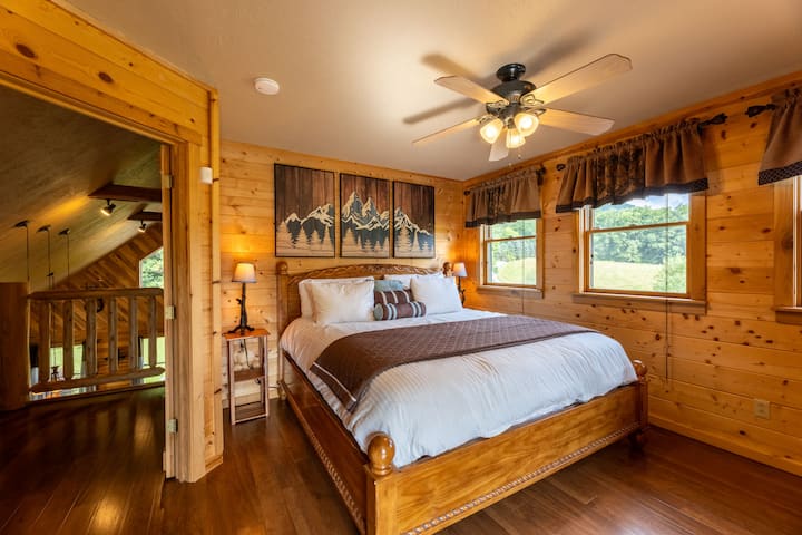 غرفة نوم رئيسية بسرير بحجم كينغ وشرفة وتلفزيون وخزانة ملابس. 