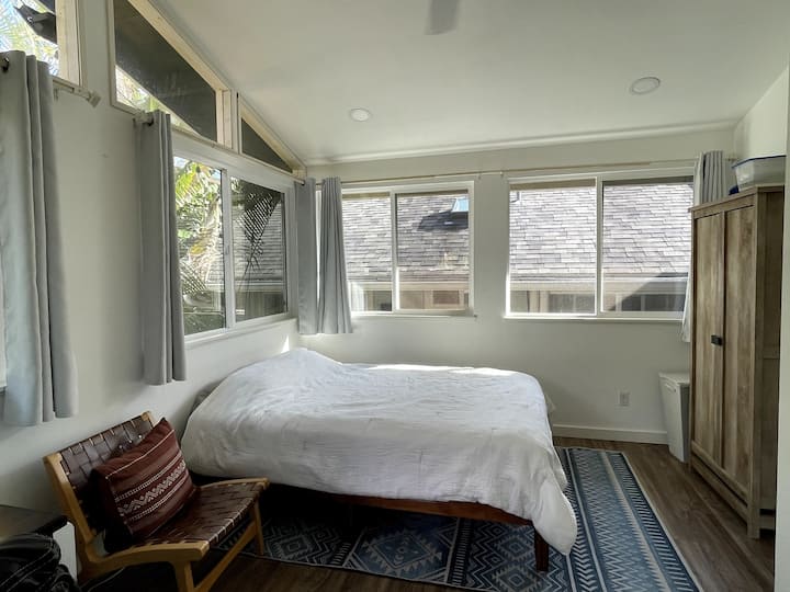 غرفة نوم رئيسية مشرقة بسرير بحجم كبير 