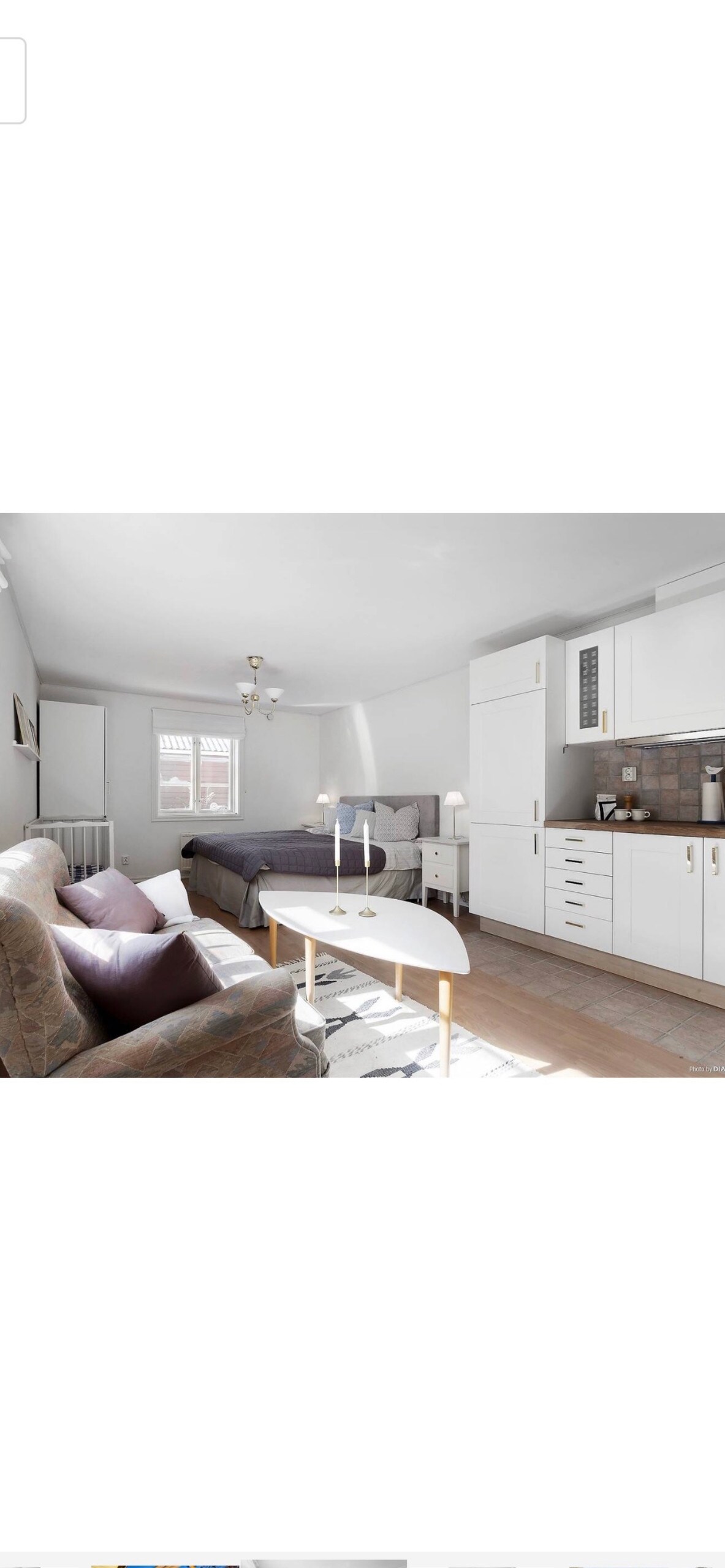 Izba penziónu s posteľou, rozkladacou pohovkou, televízorom, jedálenským stolom a kuchynkou s chladničkou.