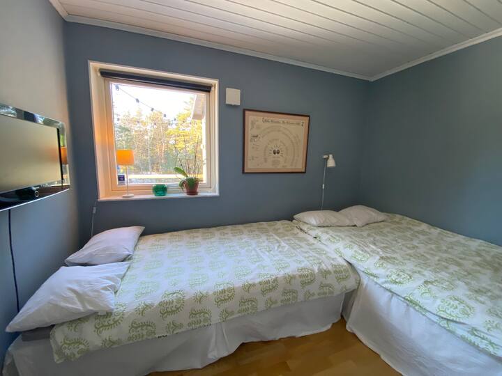 Dormitorio 5 en la planta inferior con dos camas individuales y TV. 