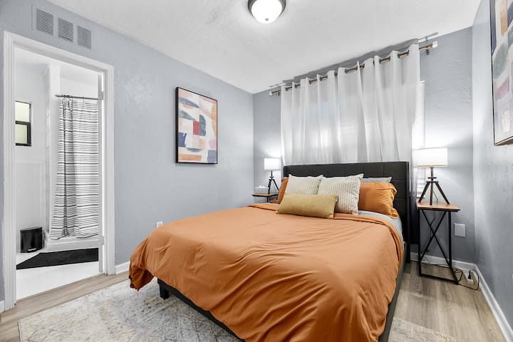 Dormitorio tamaño queen frente al patio trasero con baño privado (compartido con el dormitorio principal).