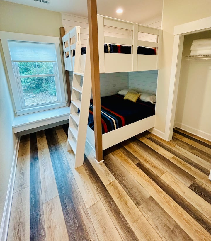 Chambre avec deux lits queen size, un grand placard et un coin salon dédié.