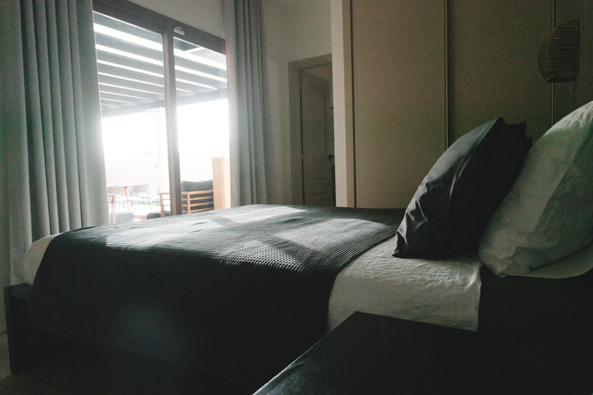 El dormitorio principal tiene su propio baño privado y acceso directo a la terraza. Desde tu cama tienes una hermosa vista matutina del patio una vez que abres las cortinas opacas al sol que están instaladas en todas las habitaciones.