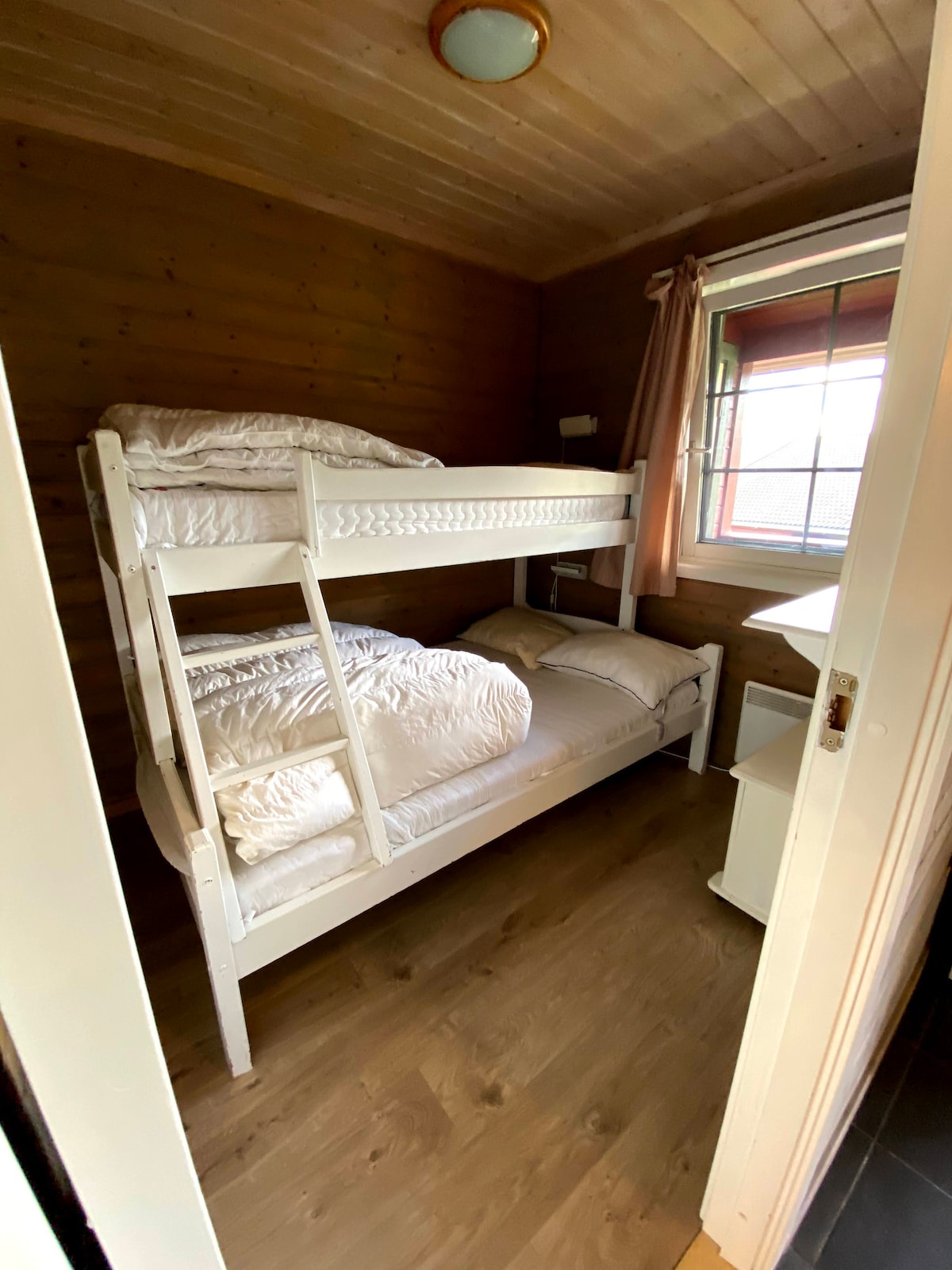 Spavaća soba s bračnim krevetom u prizemlju i krevetom na kat na katu. 