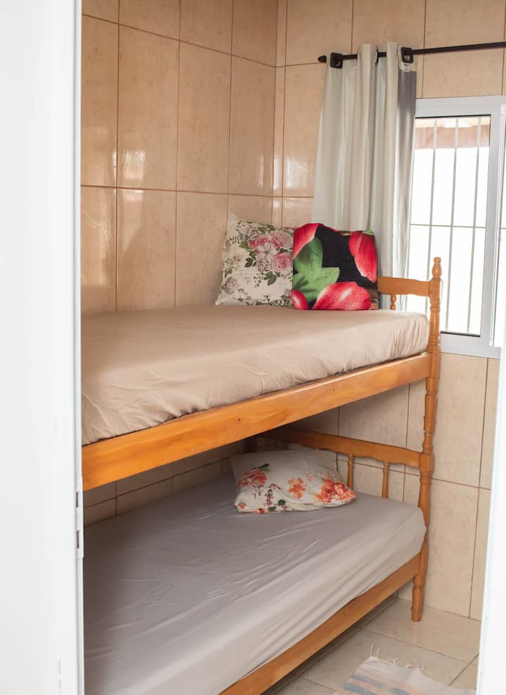 في غرفة النوم هذه 2 تجد سريرًا بطابقين ومروحة واحدة وغرفة نوم مع نافذة على حمام السباحة