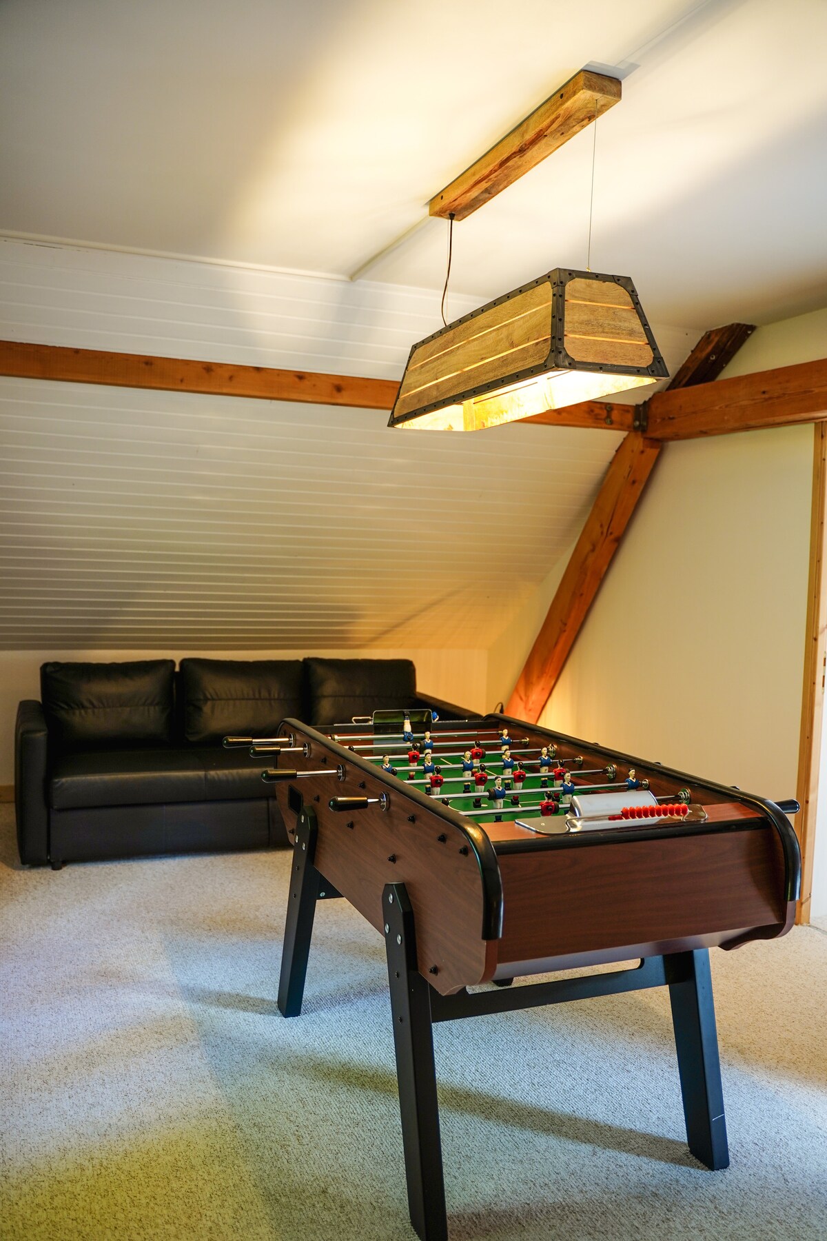 Le palier équipé d’un babyfoot, d’un jeu de fléchette et d’un canapé lit (160 x 200 cm en couchage)