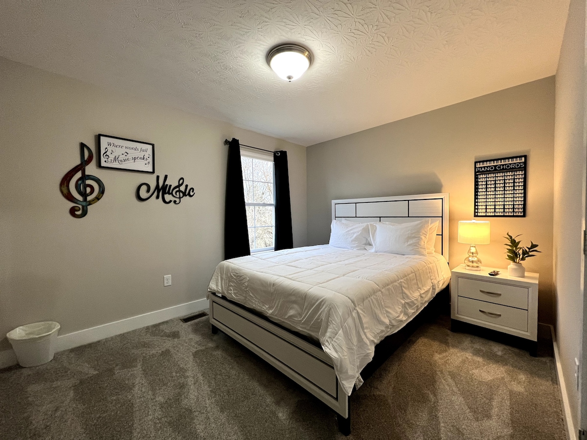 Este dormitorio tamaño queen cuenta con TV de pantalla plana, espacio de almacenamiento y luz natural.