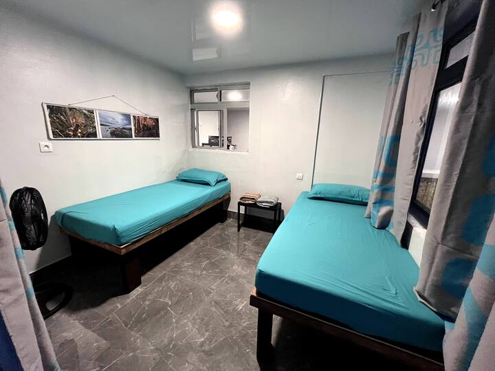 Small bedroom partitioned by curtains containing 2 single beds 90x180. 