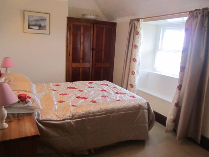 Chumba cha ukubwa wa mfalme kinatazama mbele ya nyumba na maoni yasiyo ya kawaida ya mashamba ya wazi/mnara wa taa na bahari.

Kitanda cha Ukubwa wa Mfalme kilichojengwa katika WARDROBE ya awali na kifua cha kipindi cha droo na meza mbili za upande.  