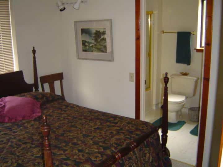 This is Bedroom 1 with a queen bed and a view of the 2nd bathroom