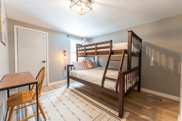 Stylish bunk room with a double bed below and single bed above.