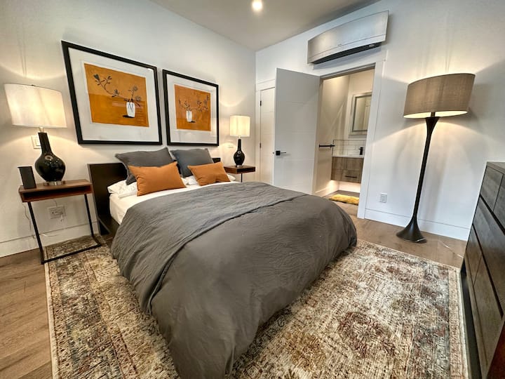 Queen Bed with luxurious linens, dresser, and closet storage.