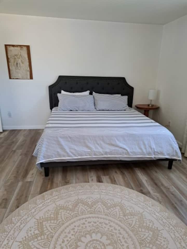 The corner king bedroom has windows on two sides to brighten the room with blackout curtains for a soothing sleep at night. 