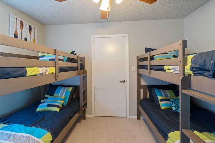 Litera, ropa de cama adicional y juguetes en el armario. Habitación con literas y literas con 4 camas de una. 