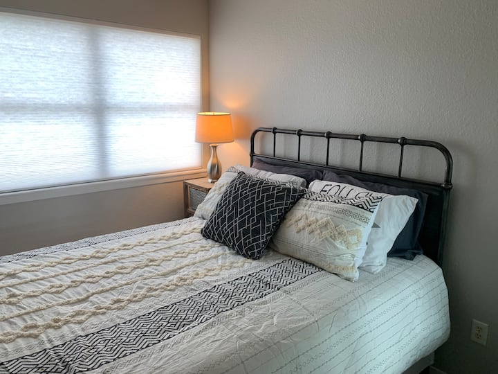 Dormitorio de invitados en la planta superior , cama tamaño queen y escritorio para computadora portátil.