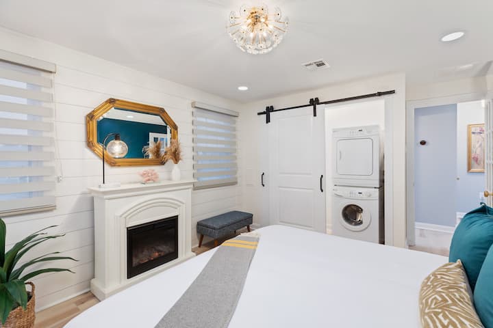 ห้องนอนใหญ่พร้อมเตียงคิงไซส์ตู้เสื้อผ้าพร้อมที่จัดระเบียบและเครื่องซักผ้า/ไดร์เป่าผมเฉดสีเข้มในห้องเตาผิงสำหรับบรรยากาศหรือความอบอุ่นเพิ่มเติมในฤดูหนาว 