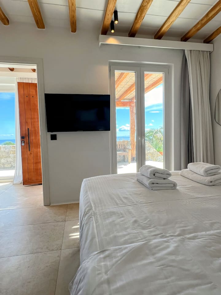 "Indulge in Mykonos luxury with a lavish bedroom and ensuite bathroom, perfect for relaxation and creating unforgettable moments in exquisite comfort."