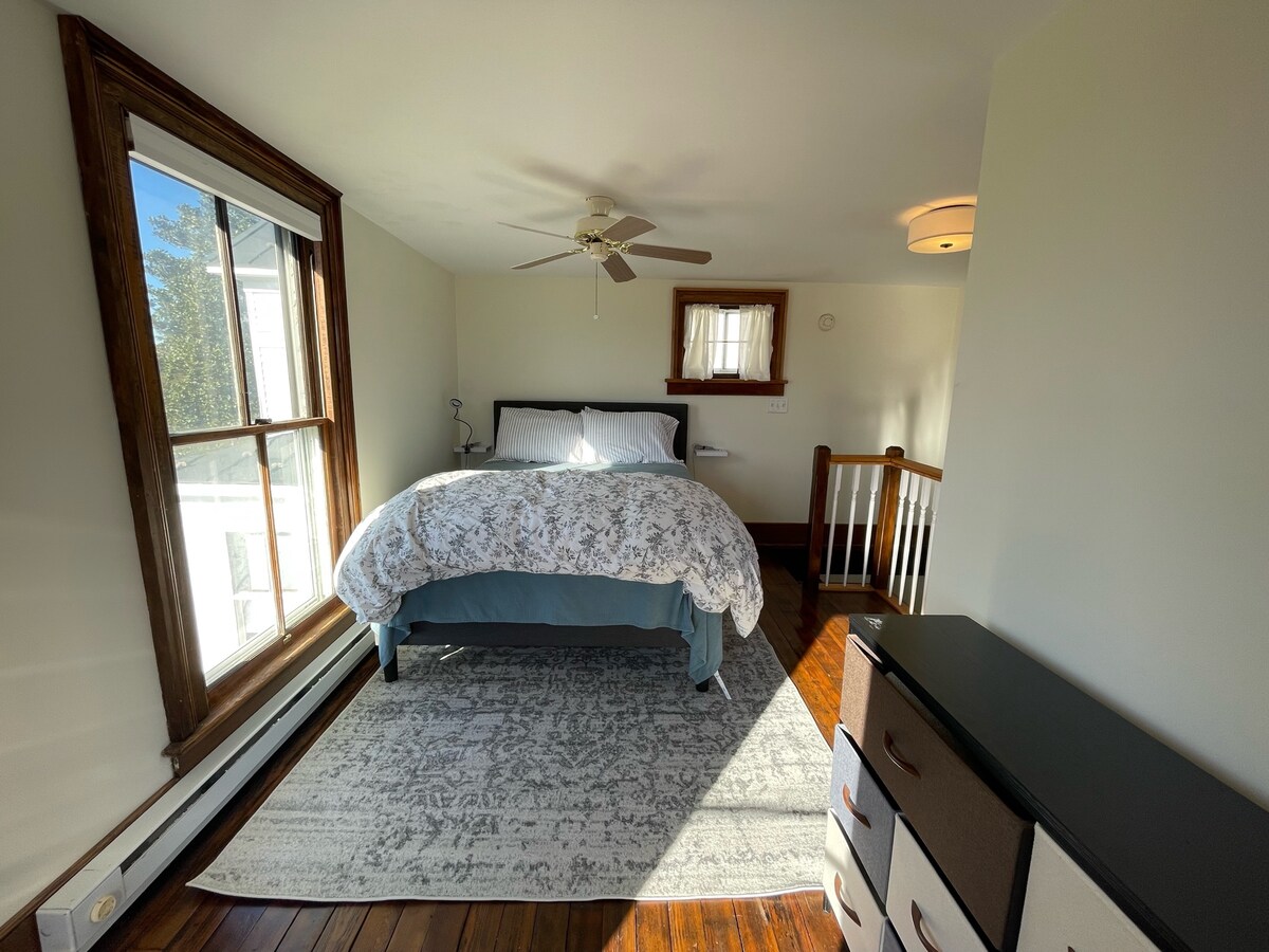 Upstairs bedroom with queen bed and dresser.