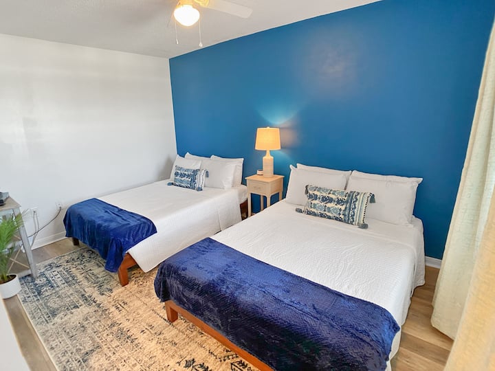 Guest bedroom featuring two full beds and a Smart TV. Bonus: Peak-a-Boo views of the lagoon through the window!