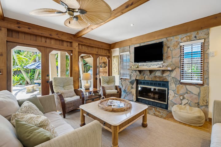 Კომფორტული ღია საოჯახო ოთახი სმარტ-ტელევიზორით, შუშის ფრანგული კარების კედლით, რომელიც აუზს გადაჰყურებს, ტროპიკული  ლანდშაფტი. Განტვირთვისთვის საკმარისი სივრცეა.