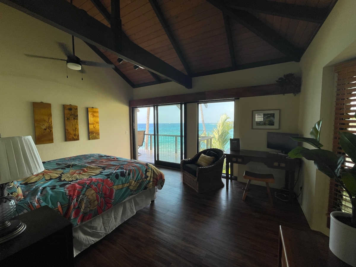 Glavna spavaća soba s pogledom na ocean i plažu Magic Sands u Pappy 's Hale Nalu (jedinica 4). Soba ima privatni lanai, glavnu kupaonicu i poseban radni prostor s monitorom.