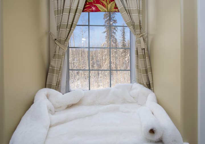 Chambre Queen à l'étage avec vue sur la baie vitrée et coin salon confortable