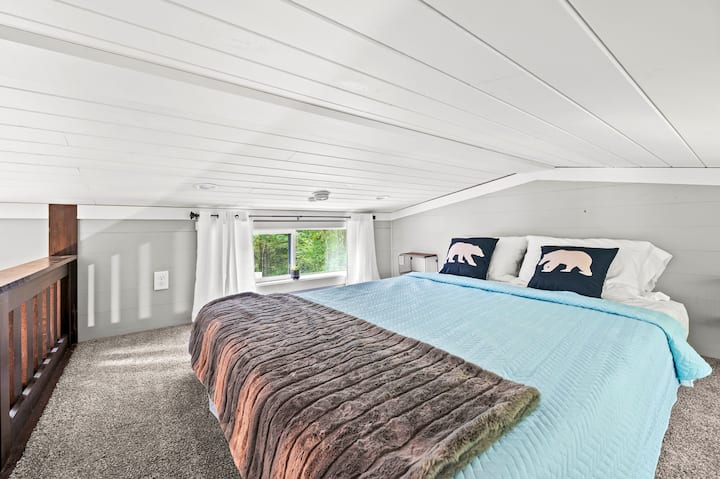 Dormitorio loft con cama tamaño queen.  