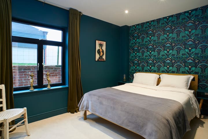 Სტუმრების საძინებელი დიდი საწოლით და დიდი კარადებით.