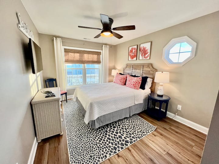 El dormitorio secundario tiene una cama queen y vistas al mar. Hay  un armario espacioso y un televisor de pantalla plana con capacidad de transmisión. La cama está vestida con sábanas de lujo a tu llegada.