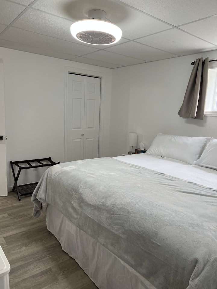 Bedroom #2 (basement) comprising:
king bed,
fan and adjustable light, 
Smart TV (Videotron), 
bedside tables with touch lamps, USB ports and electrical outlets,
digital alarm clock,
chest of drawers and 
luggage rack