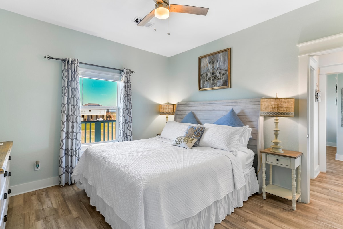 在章鱼房间的豪华加大双人床上舒适地伸展身心，是探险一天后的完美度假胜地。 此房间还可欣赏面向海湾的后阳台景观