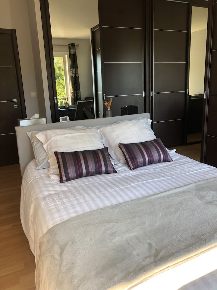 غرفة نوم رئيسية بمساحة 16 مترًا مربعًا مع مكيف هواء فردي ونافذة كبيرة مواجهة للجنوب تطل على تراس الطابق العلوي 