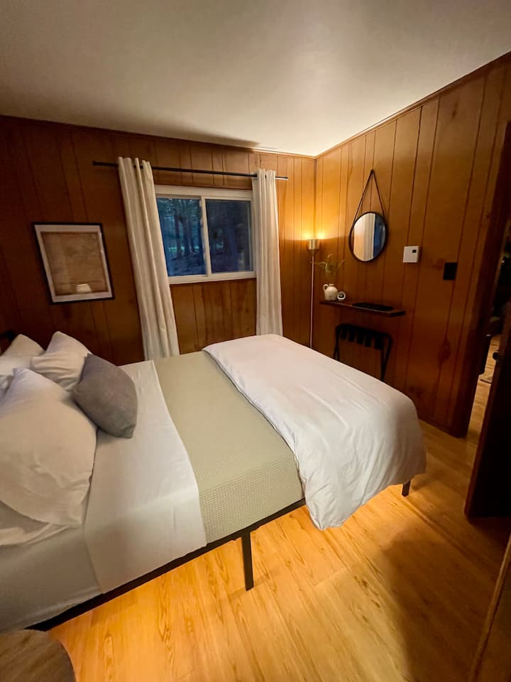 إطلالة على غرفة نوم الضيف "باك" من الحمام، في الأفق، هو سرير بحجم كوين ورف ومرآة مكياج.