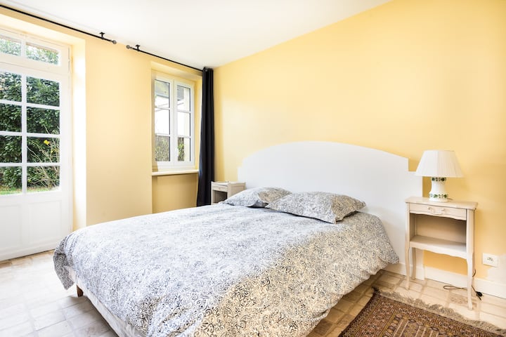 Chambre située dans la dépendance mitoyenne à la maison. Un havre de paix, avec vue sur le jardin.