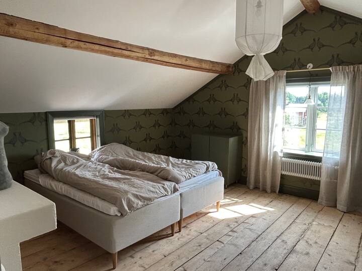 Ett stort sovrum med två enkelsängar som lätt kan sättas ihop till en dubbelsäng om man önskar det. Det finns även en gammaldags barnsäng för ett barn att sova i. Rummet har förvaring i skåp samt upphängning av kläder på klädställning och väggkokar. 