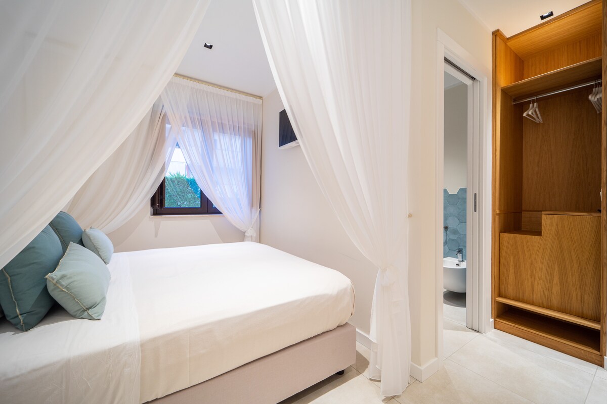 Panoramica room con letto a baldacchino, armadio , ingresso bagno, finestra