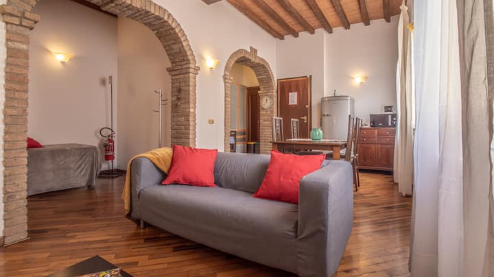 Ambient ndenjjeje me tavolinë ngrënieje, divan, kuzhinë dhe frigorifer