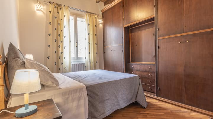 Dhomë gjumi e përbërë nga një krevat dopio, gardërobë e madhe dhe pamje nga oborri i brendshëm 