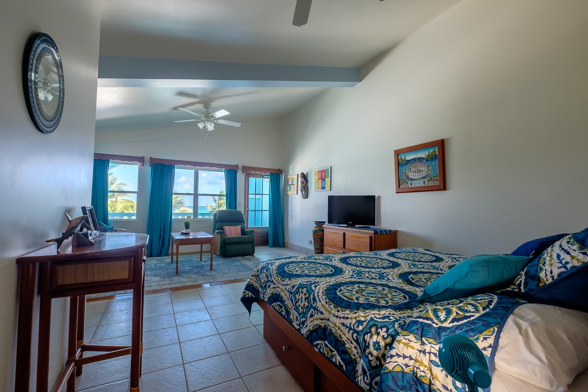 ห้องนอนคิงไซส์ขนาดใหญ่ชั้นบนพร้อมพื้นที่นั่งเล่นและระเบียงแบบเปิดโล่ง