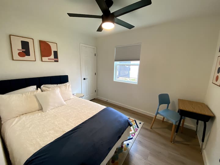 Тази стая се предлага с голямо легло, малко бюро, тъмни щори и стандартен гардероб.