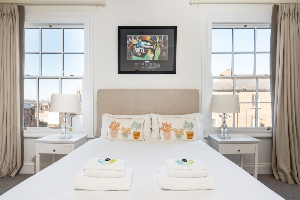 Glavna spavaća soba, s bračnim krevetom, uokvirena s dva visoka prekrasna prozora