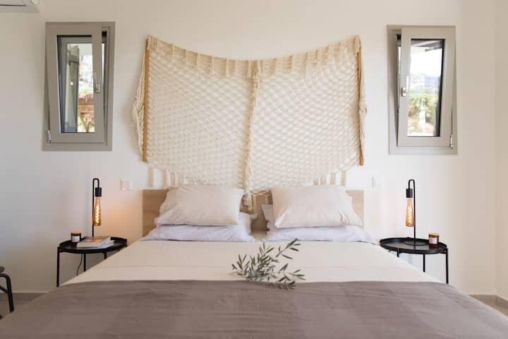 El dormitorio principal (GF). Un colchón Candia Strom para una experiencia de sueño profunda y relajante frente a un gran armario blanco brillante, un sillón para leer un libro y un baño privado.

BÚHO | athens riviera 