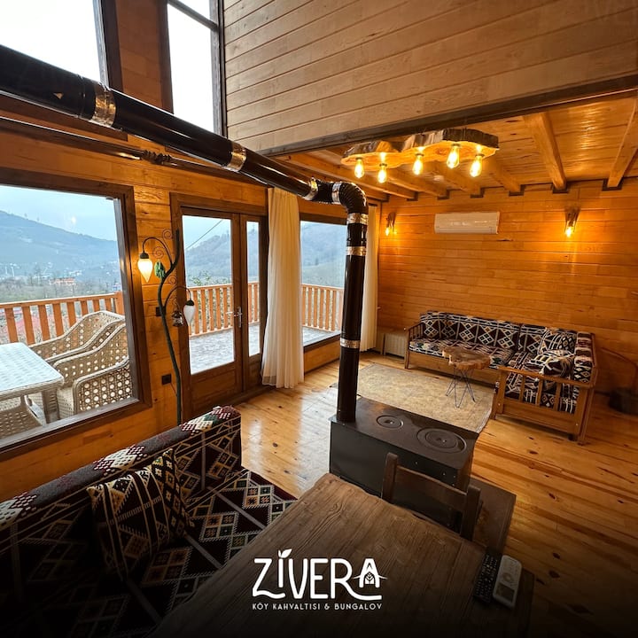 ห้องนั่งเล่นของบังกะโลของเรามีเครื่องปรับอากาศสำหรับวันที่อากาศร้อนและมีเตาครัวพร้อมเตาอบสำหรับวันที่อากาศหนาวเย็น โต๊ะรับประทานอาหารและห้องครัวอยู่ในเลานจ์