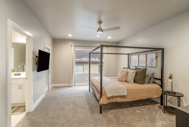 50インチのHD LGスマートテレビと遮光カーテンを備えたマスターベッドルーム