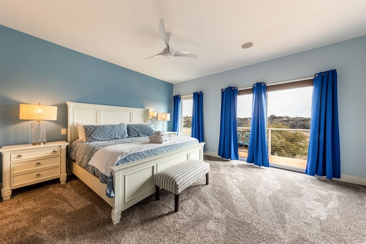 غرفة نوم أساسية مضاءة بالشمس مع سجادة فخمة وإطلالات هادئة على التلال